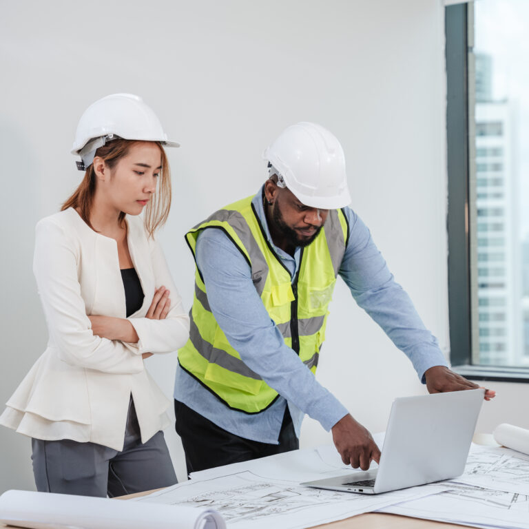 Engineers meet in the office to work on an architectural project as a team.